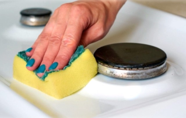 Чистка плиты: наносим средство и накрываем полотенцем